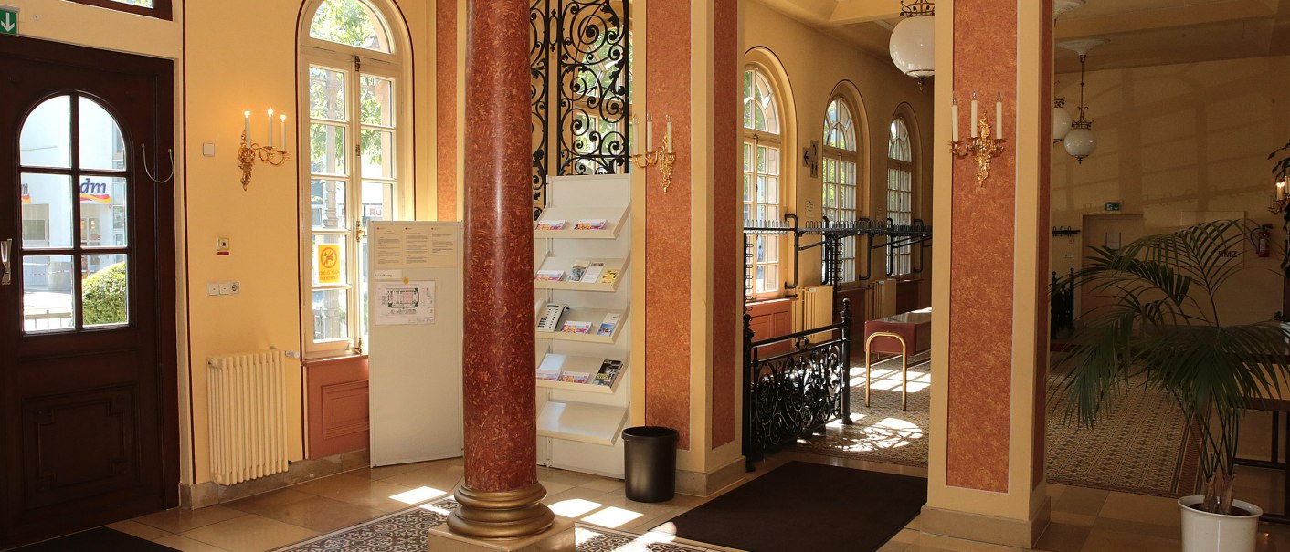 Elegant entrance area of the Ludwigsburg Music Hall with columns, large windows and decorative details. Inviting atmosphere with warm colors., © Wolfgang List