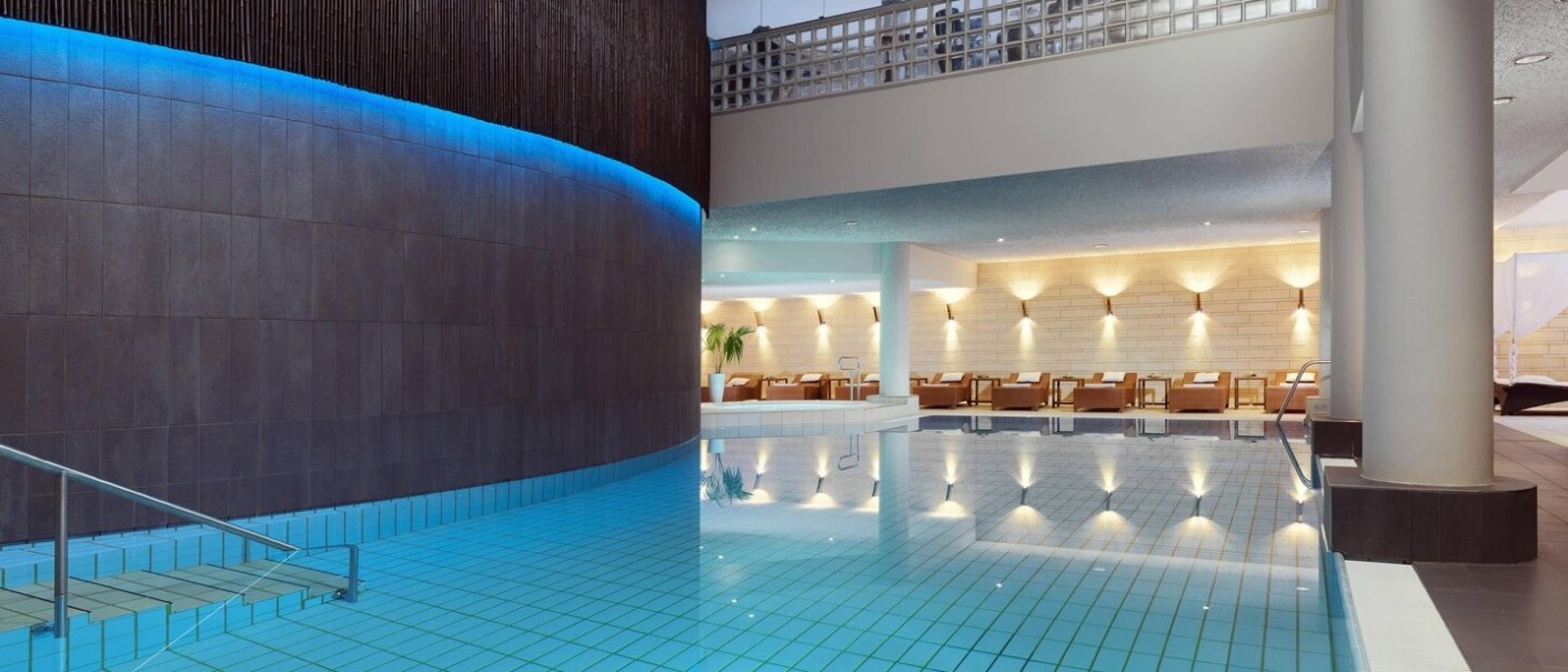 Modern hotel pool at Le Méridien Stuttgart with blue lighting, sun loungers and elegant architecture., © Le Méridien Stuttgart Modern hotel pool at Le Méridien Stuttgart with blue lighting, sun loungers and elegant architecture., © Le Méridien Stuttgart