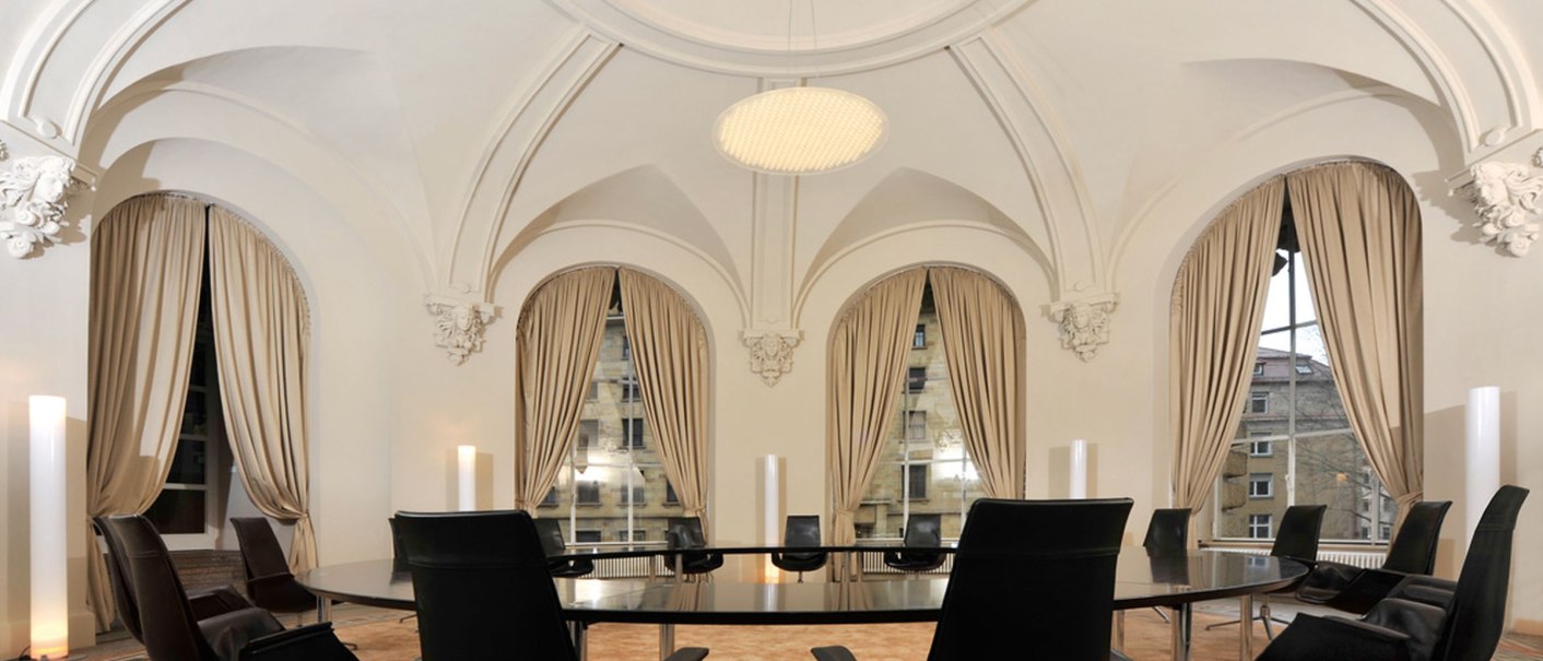 Eleganter Konferenzraum im Haus der Wirtschaft Baden-Württemberg mit gewölbter Decke, großen Fenstern und schwarzen Stühlen um einen ovalen Tisch., © Udo W Beier