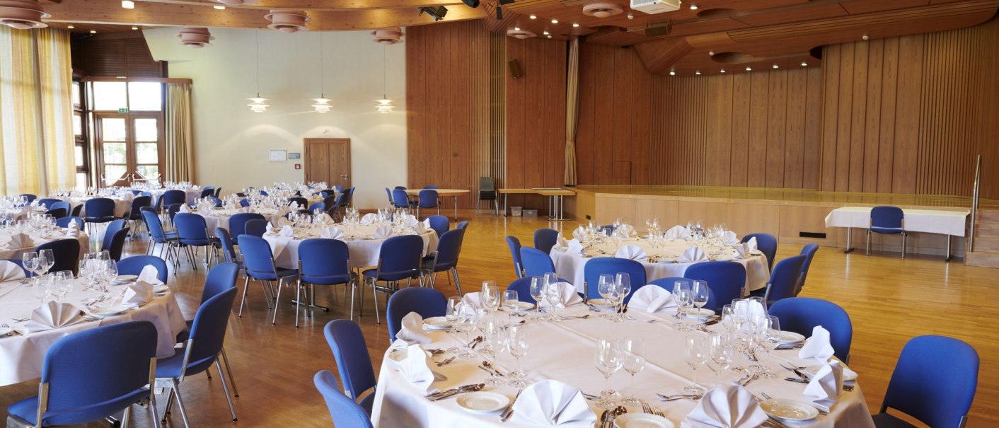 Elegant hall with round tables, blue chairs and white tablecloths, ready for an event in the Waiblingen Civic Center, Welfensaal., © Peter Oppenländer Elegant hall with round tables, blue chairs and white tablecloths, ready for an event in the Waiblingen Civic Center, Welfensaal., © Peter Oppenländer