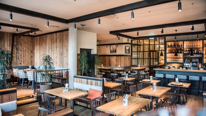 Modern brewery with wooden furniture, bar and plants. Cozy atmosphere with wooden walls and stylish lighting., © Andreas Engelhard - Engelhard Photography Modern brewery with wooden furniture, bar and plants. Cozy atmosphere with wooden walls and stylish lighting., © Andreas Engelhard - Engelhard Photography