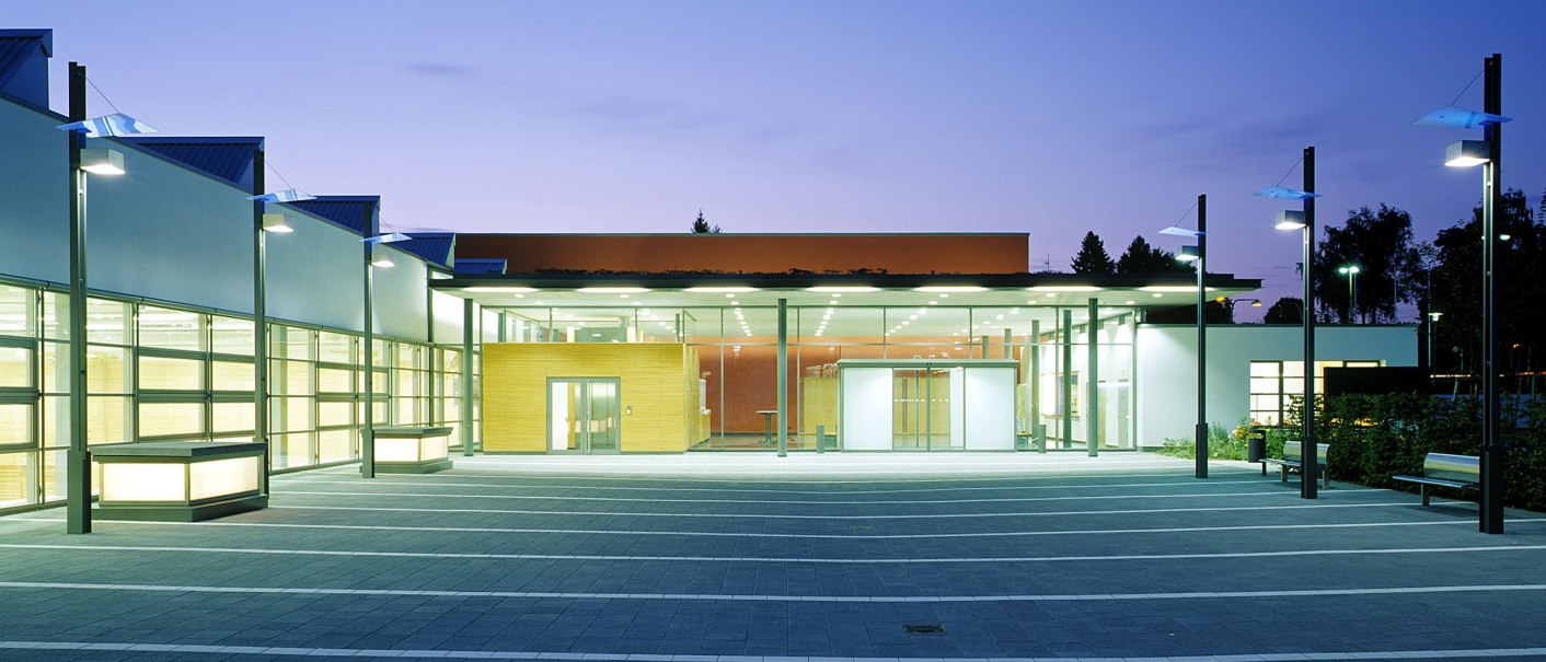 Modern festival hall Schmiden at dusk, illuminated entrance, clear lines, large window fronts, paved forecourt., &copy; dietmar strauss