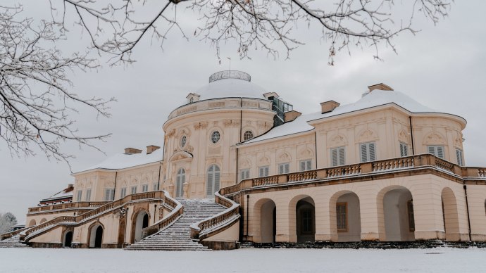 Schloss Solitude im Winter, bedeckt mit Schnee. Ein pr&auml;chtiges Geb&auml;ude mit geschwungenen Treppen und kahlen B&auml;umen im Vordergrund., &copy; SMG Thomas Niederm&uuml;ller