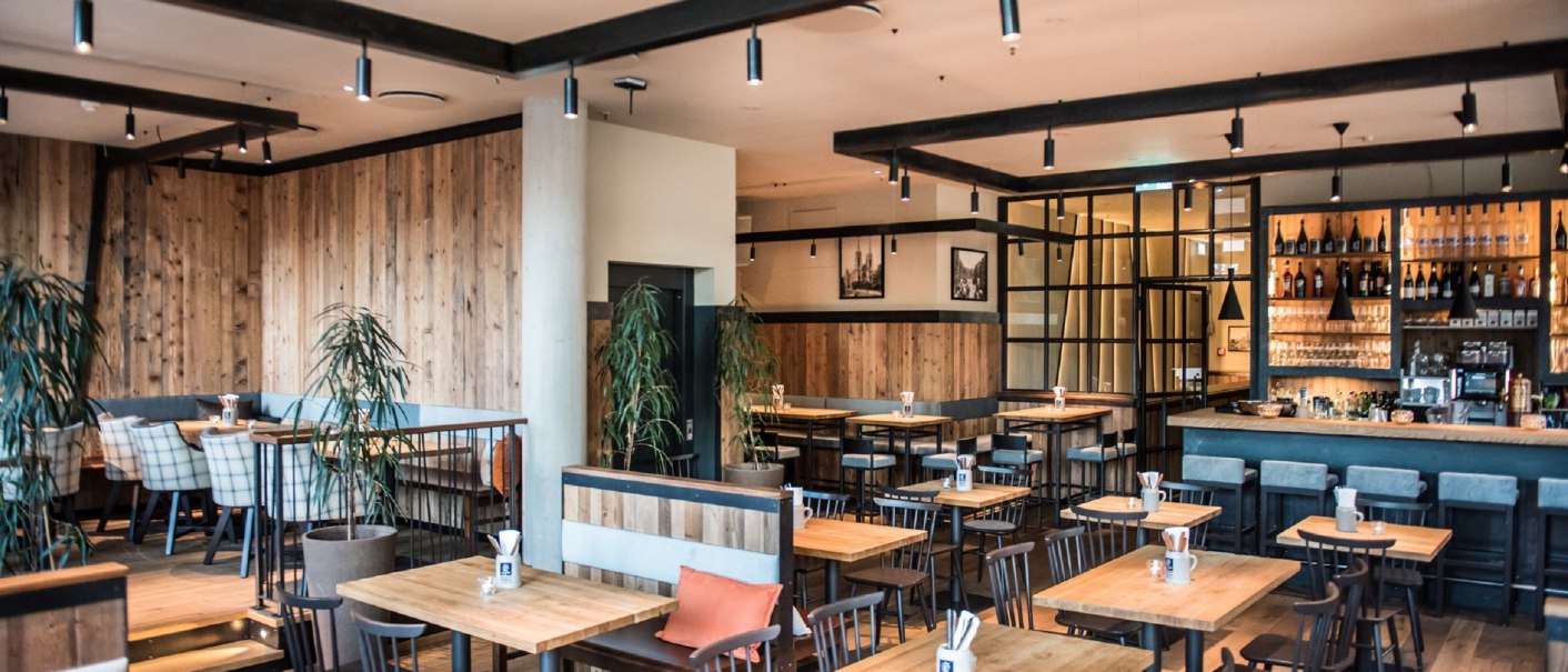 Modern brewery with wooden furniture, bar and plants. Cozy atmosphere with wooden walls and stylish lighting., © Andreas Engelhard - Engelhard Photography Modern brewery with wooden furniture, bar and plants. Cozy atmosphere with wooden walls and stylish lighting., © Andreas Engelhard - Engelhard Photography