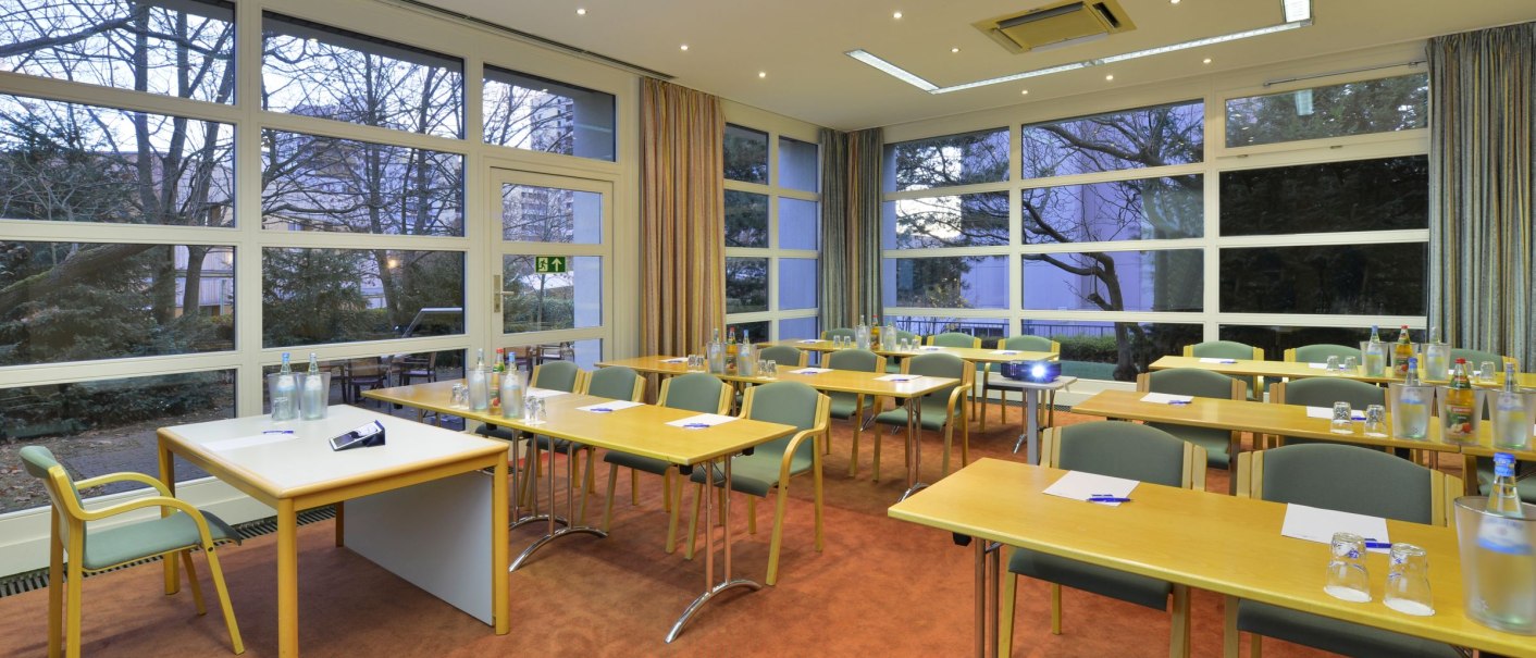 A bright meeting room with large windows, several tables and chairs. There are water bottles and glasses on the tables., &copy; DH STUDIO Dirk Holst