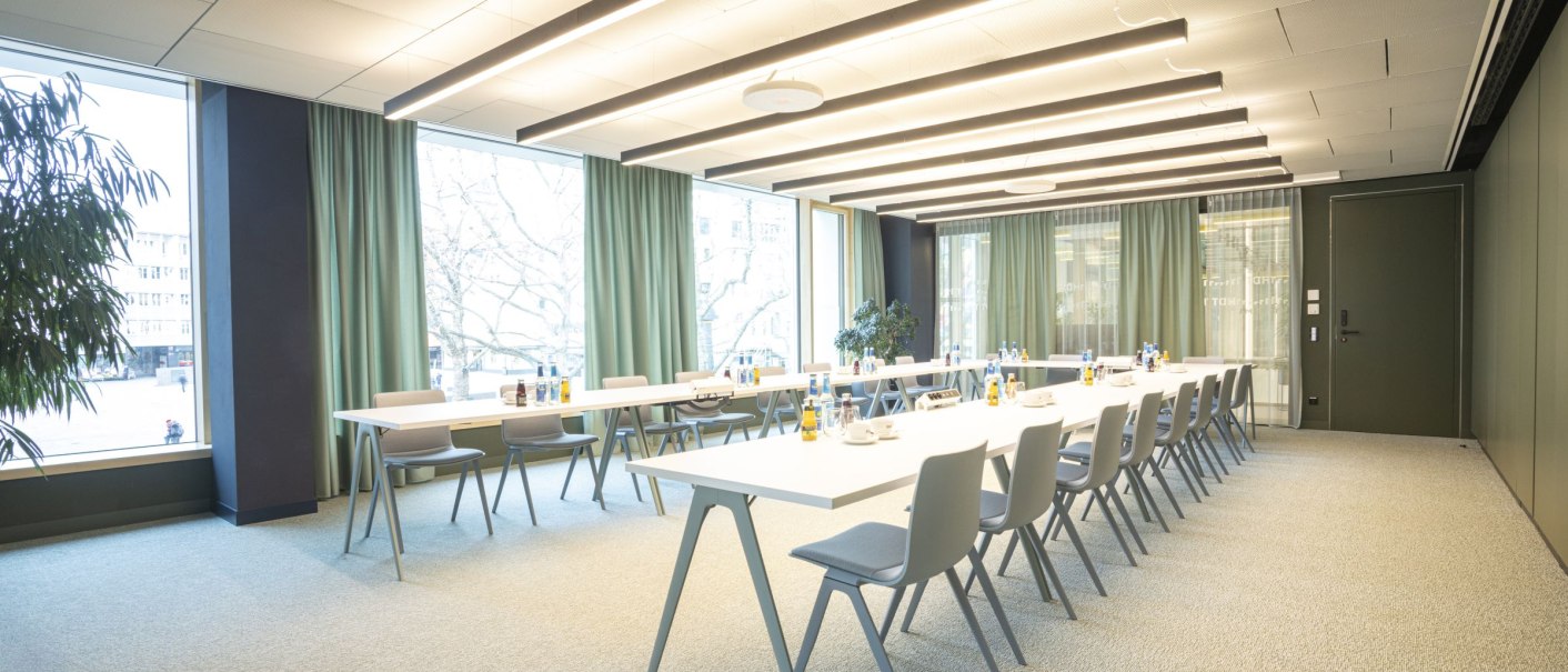 A modern conference room with long tables, chairs and large windows. The green curtains and plants create a pleasant atmosphere., &copy; SMG Stuttgart Marketing GmbH - Sarah Schmid