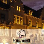 The Stuttgarter Schlachthof restaurant is illuminated at night. The fa&ccedil;ade features a pig museum and a caf&eacute;., &copy; Wilhelmer Gastronomiebetriebe GmbH