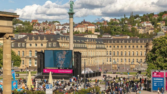 People gather in front of a large screen on Schlossplatz in Stuttgart. The New Palace can be seen in the background., &copy; SMG, Sarah Schmid