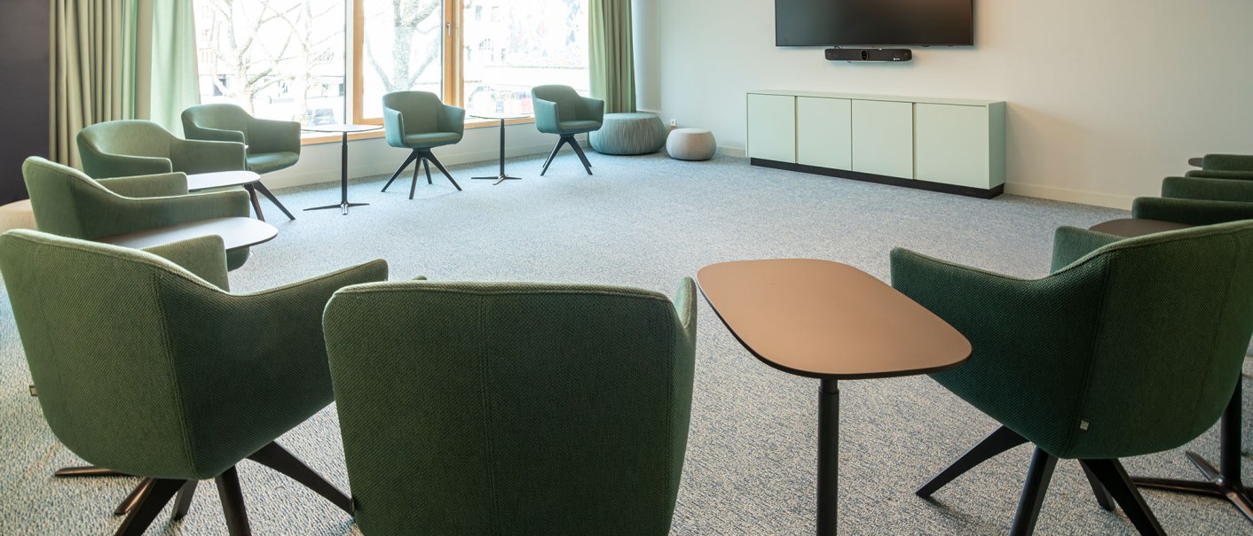 A modern meeting room with green chairs, small tables and a large screen. Large windows let in plenty of light., © SMG Stuttgart Marketing GmbH - Sarah Schmid A modern meeting room with green chairs, small tables and a large screen. Large windows let in plenty of light., © SMG Stuttgart Marketing GmbH - Sarah Schmid