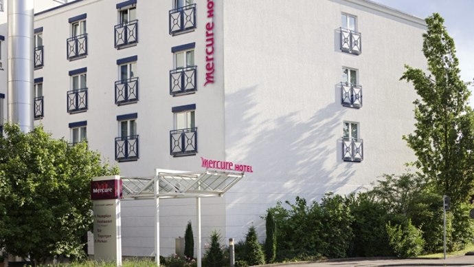 Au&szlig;enansicht des Mercure Hotels in Stuttgart mit wei&szlig;er Fassade, blauen Fensterrahmen und umliegenden B&auml;umen., &copy; Mercure Stuttgart Airport Messe