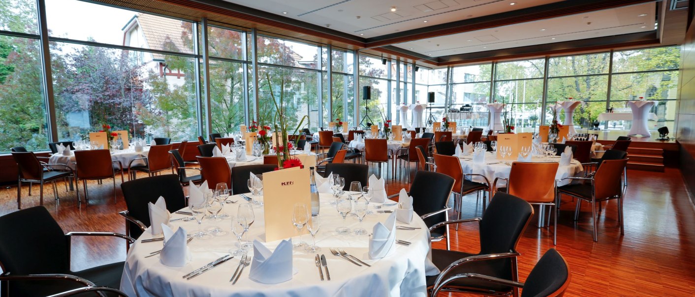 Eleganter Panoramasaal mit großen Fenstern, gedeckten Tischen und stilvoller Dekoration. Perfekt für Veranstaltungen und Feiern., © k3nmaisch_tf