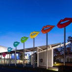 Die FILharmonie bei Dämmerung, mit bunten Lippen-Skulpturen auf hohen Stangen vor dem Gebäude., © Filharmonie_gf Die FILharmonie bei Dämmerung, mit bunten Lippen-Skulpturen auf hohen Stangen vor dem Gebäude., © Filharmonie_gf