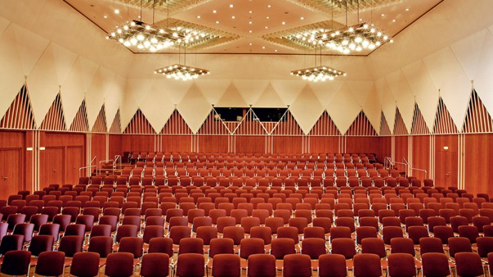Gro&szlig;er Konferenzsaal mit roten St&uuml;hlen, moderner Beleuchtung und geometrischen Wandmustern im Kronenzentrum Bietigheim-Bissingen., &copy; Kronenzentrum Bietigheim-Bissingen