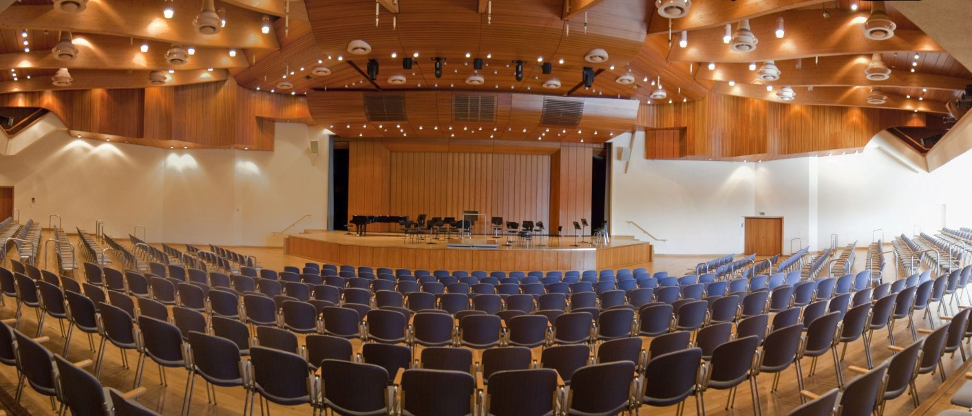 The Ghibellinensaal in the Waiblingen community center shows empty rows of chairs and a stage. The ceiling is made of wood with lighting., © Peter Oppenländer The Ghibellinensaal in the Waiblingen community center shows empty rows of chairs and a stage. The ceiling is made of wood with lighting., © Peter Oppenländer