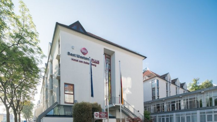 Ein modernes Hotelgebäude mit Best Western Plus Logo, umgeben von Bäumen und Fahnenmasten., © (c) Florian Busch Ein modernes Hotelgebäude mit Best Western Plus Logo, umgeben von Bäumen und Fahnenmasten., © (c) Florian Busch