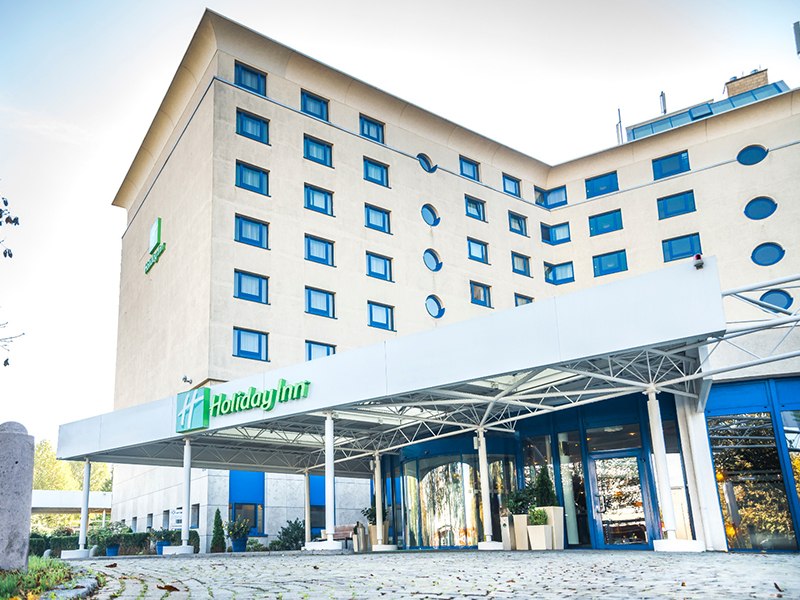 Eingang des Holiday Inn Stuttgart mit moderner Architektur, Glasfront und markantem Logo. Mehrst&ouml;ckiges Geb&auml;ude mit vielen Fenstern., &copy; Nutzungsrechte obliegt nur dem direkten Auftraggeber