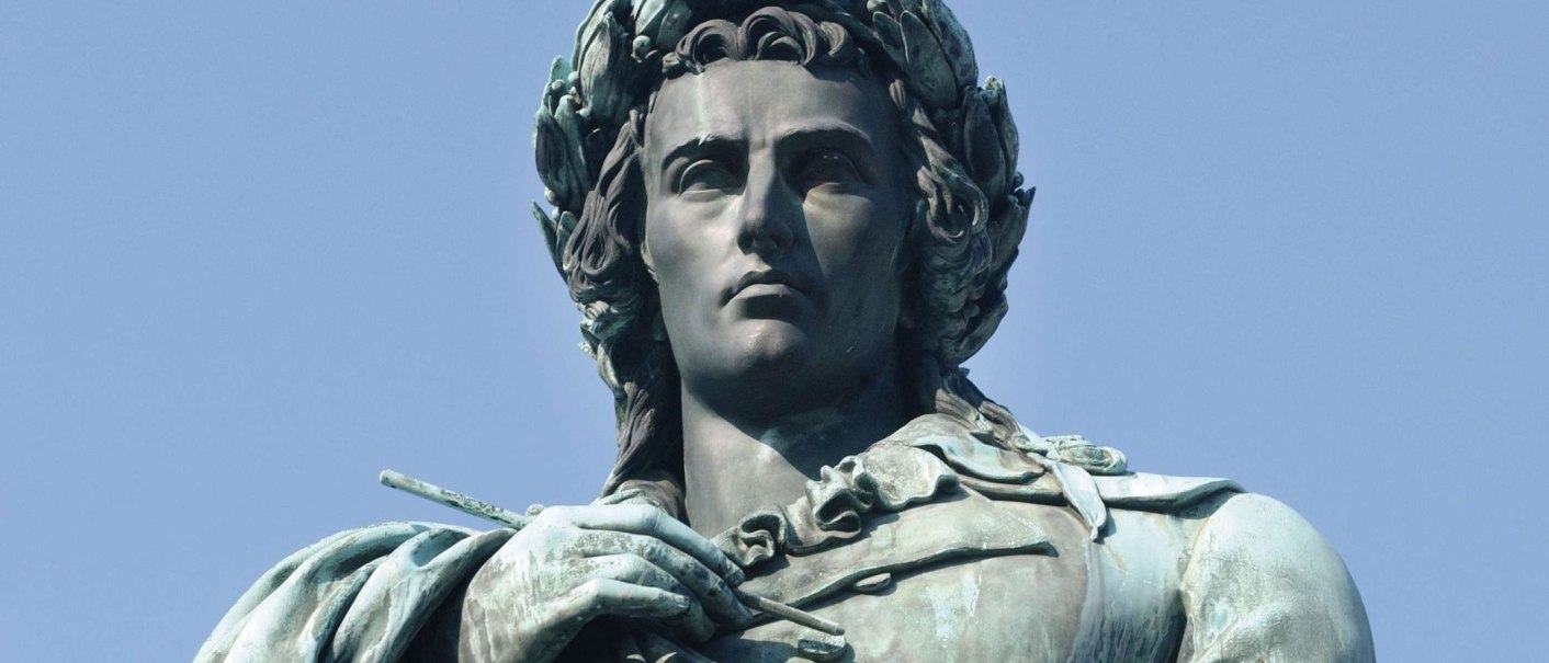 Nahaufnahme einer Schillerstatue mit Lorbeerkranz, die in den Himmel blickt. Der Hintergrund ist ein klarer blauer Himmel., © SMG, Günter Bergmann