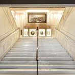 Elegant staircase in the House of History Baden-Württemberg, decorated with paintings and a bust on the wall., © danielstauch_gf
