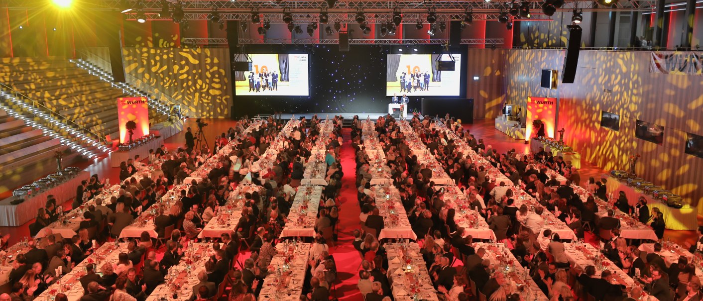 The Great Hall of the Carmen Würth Forum is festively lit. Many guests are seated at long, laid tables. A stage is visible in the background., © VEROEFFENTLICHUNG GEGEN HONORAR
