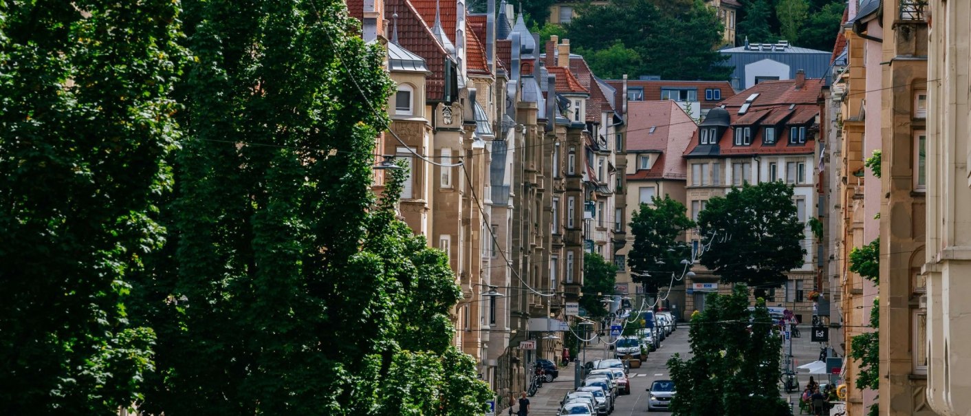 Straße im Stuttgarter Süden mit historischen Gebäuden und Bäumen. Autos parken am Straßenrand, und die Architektur zeigt rote Ziegeldächer und verzierte Fassaden., © Thomas Niedermüller