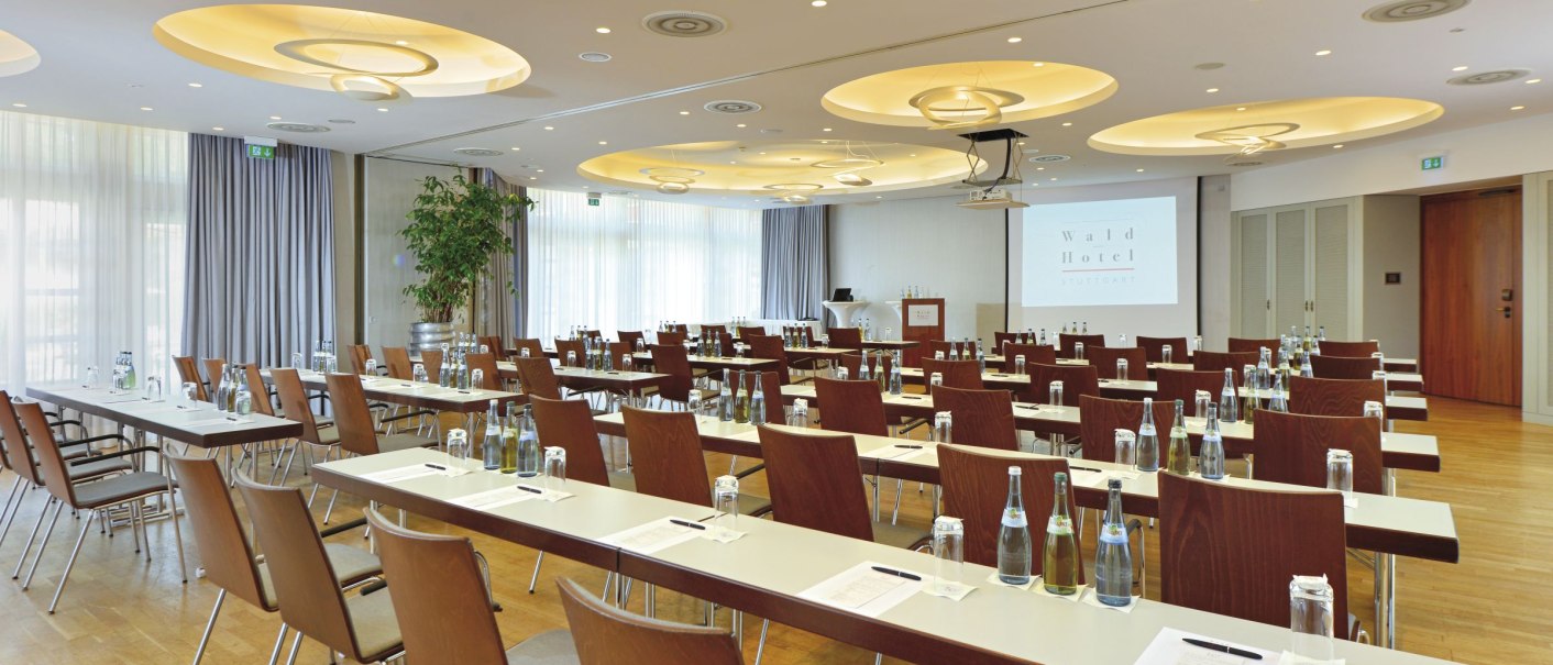 Modern conference room at the Waldhotel Stuttgart with tables, chairs and presentation technology. Bright lighting and large windows., © WHS Modern conference room at the Waldhotel Stuttgart with tables, chairs and presentation technology. Bright lighting and large windows., © WHS