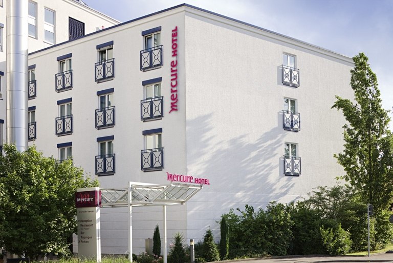Exterior view of the Mercure Hotel in Stuttgart with white fa&ccedil;ade, blue window frames and surrounding trees., &copy; Mercure Stuttgart Airport Messe