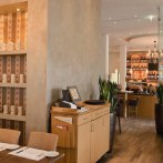 Stilvolles Restaurant mit Holzmöbeln, Regalen voller Tassen und einer gemütlichen Atmosphäre. Gäste sitzen an Tischen, im Hintergrund eine Bar., © Aspectus Photographie Stuttgart