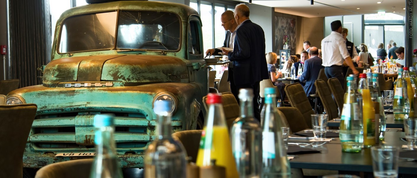 An old Dodge truck in the foyer of the V8 Hotel, surrounded by guests and laid tables. Event as part of the IHA Hotel Congress 2019., &copy; Hardy Mutschler