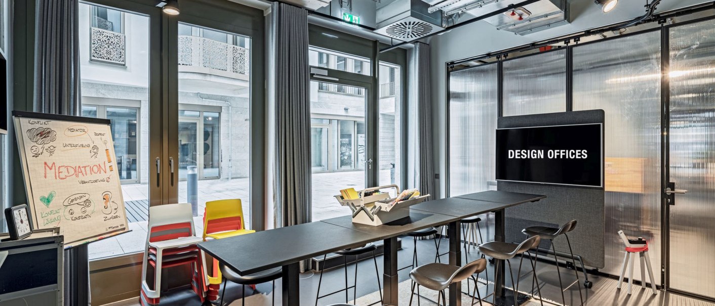 Modern meeting room with high tables and chairs, flipchart and screen labeled 'Design Offices'., &copy; Design Offices