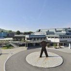 The Schwabenlandhalle Fellbach with modern architecture, surrounded by green spaces and a sculpture in the foreground. Hills can be seen in the background., © Peter Hartung