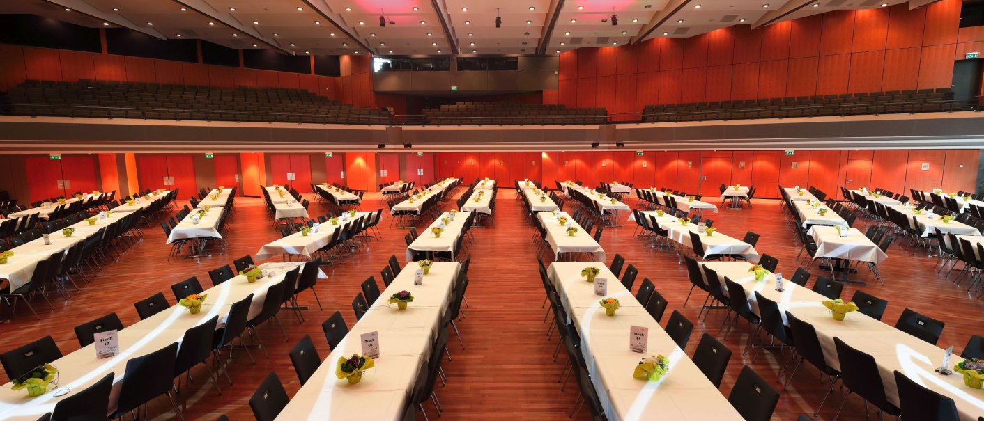 The Europasaal of the Kongresshalle Böblingen with long, laid tables and chairs, ready for an event., © ccbs-gf