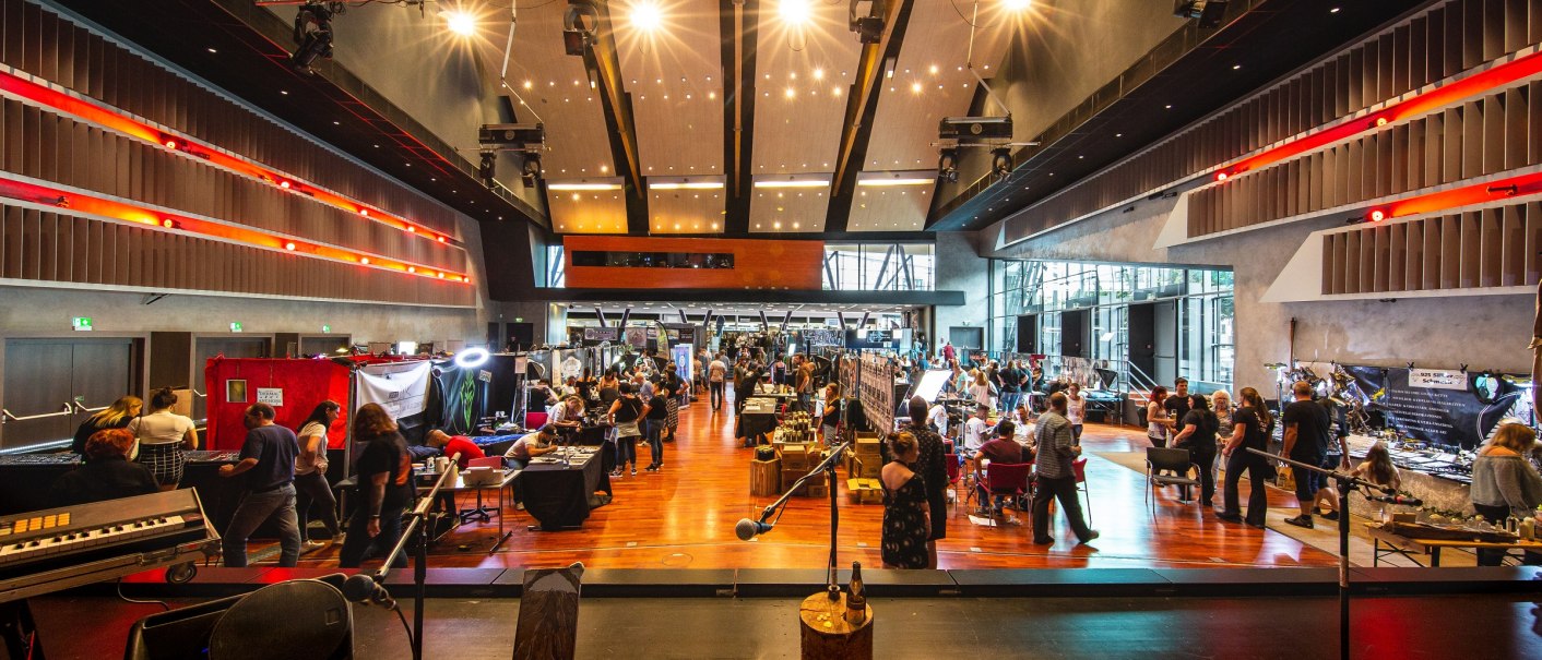 Gro&szlig;er Saal des Neckar Forums mit vielen Menschen und St&auml;nden. Die Decke ist hoch, mit Lichtern und Akustikpaneelen. Eine B&uuml;hne im Vordergrund., &copy; eslive