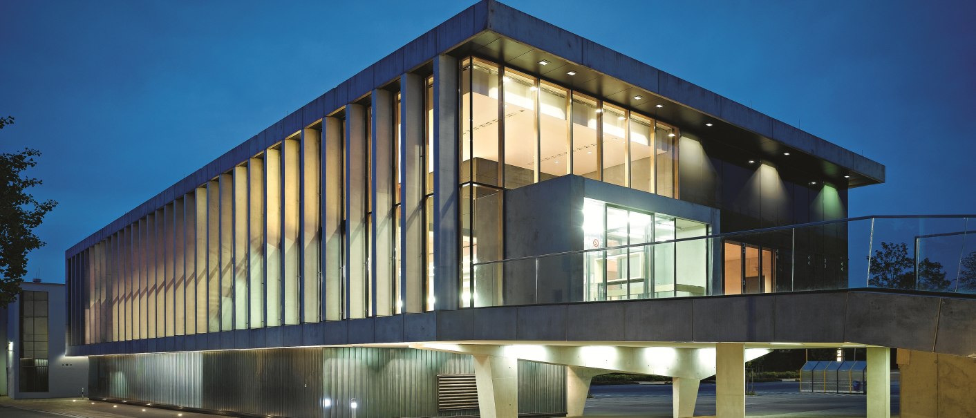 Moderne Architektur des Kulturzentrums Tamm bei Nacht. Das Gebäude ist beleuchtet und zeigt eine Glasfassade mit vertikalen Streben., © Zooey Braun