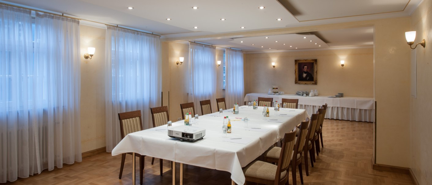 Eleganter Konferenzraum mit großem Tisch, Stühlen und Porträt an der Wand. Helle Beleuchtung und Vorhänge schaffen eine einladende Atmosphäre., © Landschloss Korntal-tg Eleganter Konferenzraum mit großem Tisch, Stühlen und Porträt an der Wand. Helle Beleuchtung und Vorhänge schaffen eine einladende Atmosphäre., © Landschloss Korntal-tg