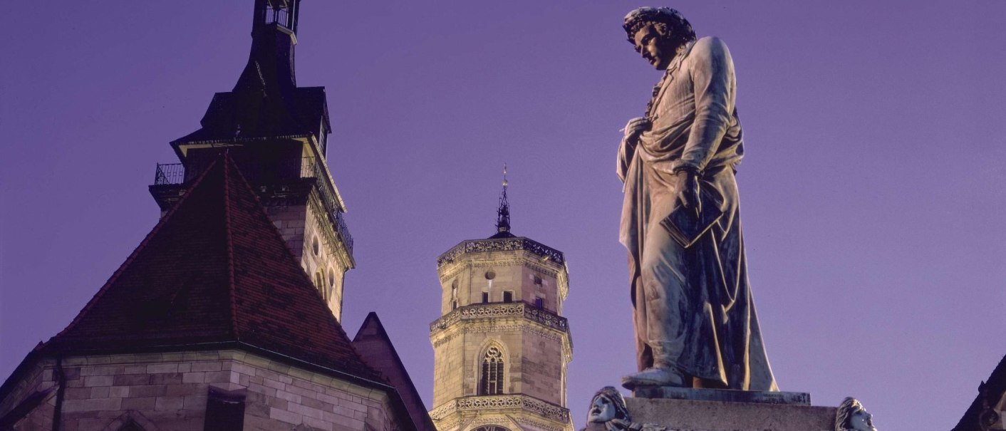 Die Stiftskirche und das Schillerdenkmal bei Dämmerung. Die Statue steht im Vordergrund, während die Kirche im Hintergrund zu sehen ist., © Stuttgart-Marketing GmbH