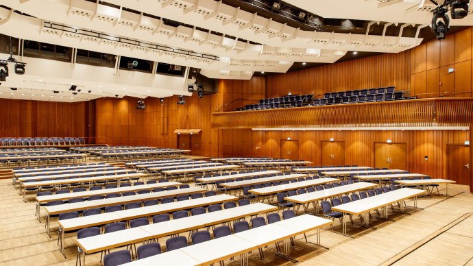 Large hall in the Stadthalle G&ouml;ppingen with empty tables and chairs, wooden walls and modern lighting., &copy; Tobias Fr&ouml;hner Photography