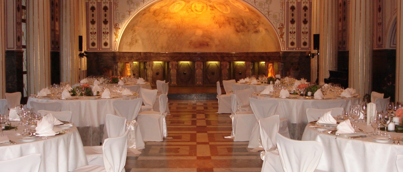 Eleganter Marmorsaal mit sechs runden, wei&szlig; gedeckten Tischen, dekorativen S&auml;ulen und kunstvoller Deckenbeleuchtung., &copy; marmorsaalgmbh