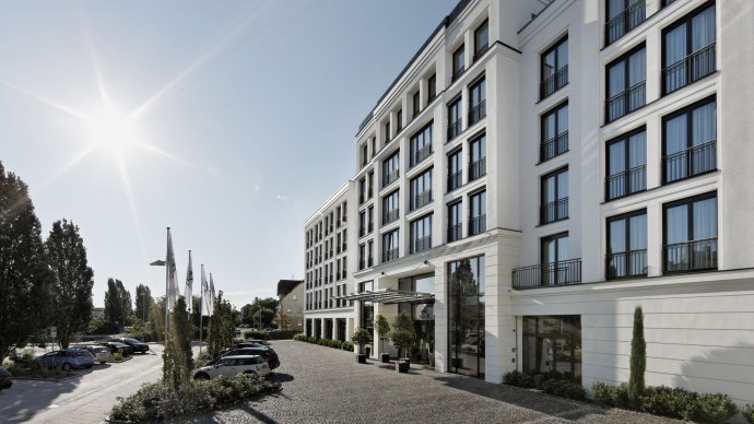 Das Parkhotel Stuttgart Messe-Airport bei Sonnenschein, mit moderner Fassade und gepflastertem Vorplatz. Autos parken entlang der Straße., © Parkhotel Stuttgart Messe-Airport GmbH & Co KG
