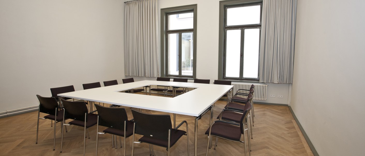 A bright conference room with a square table surrounded by chairs. Wooden floor and large windows with curtains., © Forum Koenig-Karls-BadF A bright conference room with a square table surrounded by chairs. Wooden floor and large windows with curtains., © Forum Koenig-Karls-BadF