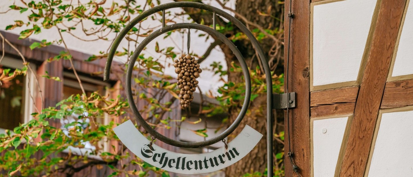 Schild mit 'Schellenturm' an Fachwerkhaus, umgeben von grünen Blättern., © Thomas Niedermüller
