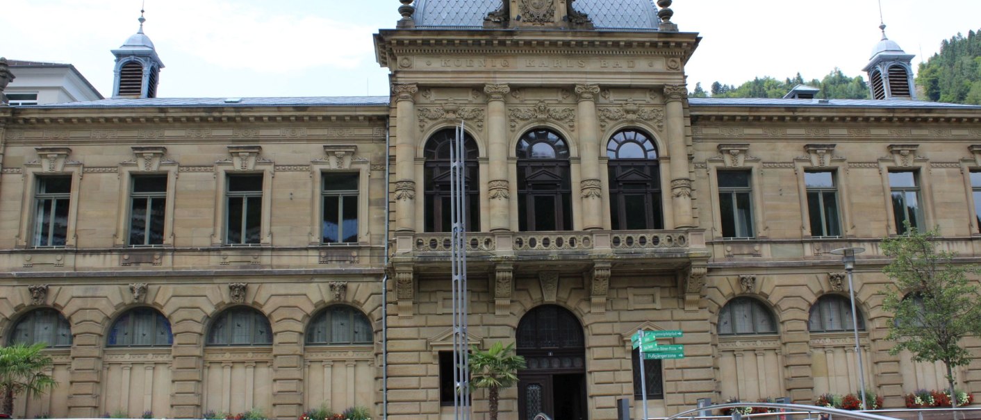 Historic building with a dome and ornate windows, with a modern bridge in front. Signage and plants adorn the entrance area., © Forum Koenig-Karls-Bad Historic building with a dome and ornate windows, with a modern bridge in front. Signage and plants adorn the entrance area., © Forum Koenig-Karls-Bad