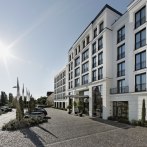Das Parkhotel Stuttgart Messe-Airport bei Sonnenschein, mit moderner Fassade und gepflastertem Vorplatz. Autos parken entlang der Stra&szlig;e., &copy; Parkhotel Stuttgart Messe-Airport GmbH & Co KG