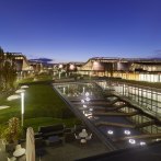 Night shot of Messe Stuttgart with illuminated buildings, green areas and water basins. Modern architecture under a clear evening sky., &copy; Roland Halbe