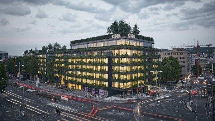 Begrüntes Gebäude in der Stadt bei Dämmerung, beleuchtete Fenster, Straßenverkehr mit Lichtspuren, Wolken am Himmel., © Ferdinand Piëch Holding GmbH Begrüntes Gebäude in der Stadt bei Dämmerung, beleuchtete Fenster, Straßenverkehr mit Lichtspuren, Wolken am Himmel., © Ferdinand Piëch Holding GmbH