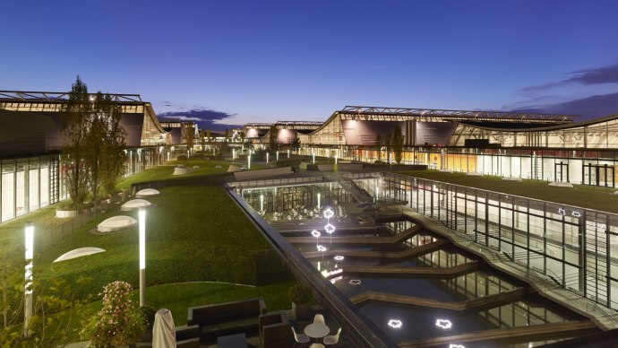 Nachtaufnahme der Messe Stuttgart mit beleuchteten Geb&auml;uden, Gr&uuml;nfl&auml;chen und Wasserbecken. Moderne Architektur unter klarem Abendhimmel., &copy; Roland Halbe