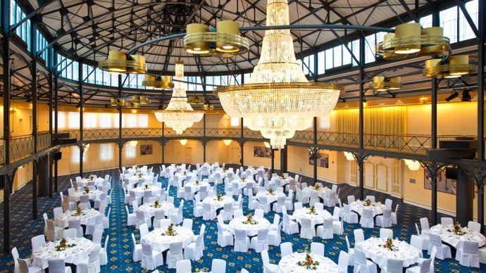 Eleganter Saal mit runden, weiß gedeckten Tischen, großen Kronleuchtern und blauer Teppichboden im Maritim Hotel Stuttgart., © Maritim Hotelgesellschaft mbH