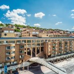 The Le Méridien Hotel in Stuttgart in sunny weather, surrounded by green hills and blue skies., © Le Méridien Stuttgart
