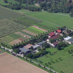 Luftaufnahme eines Bauernhofs mit mehreren Gebäuden, Gewächshäusern und Feldern. Ein Labyrinth ist in einem Feld zu erkennen., © Sonnenhof GmbH & Co KG
