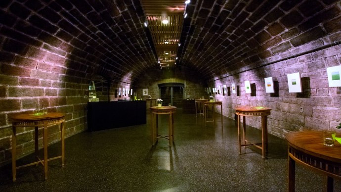 A vaulted cellar with brick walls, wooden tables and pictures on the walls. The lighting is warm and creates a cozy atmosphere., &copy; &copy; SMG, Darryl MacDonald