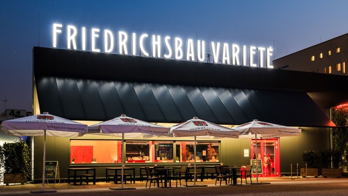 Das Friedrichsbau Variet&eacute; bei Nacht, beleuchteter Schriftzug, Sonnenschirme und Tische im Vordergrund., &copy; Friedrichsbau Variet&eacute;